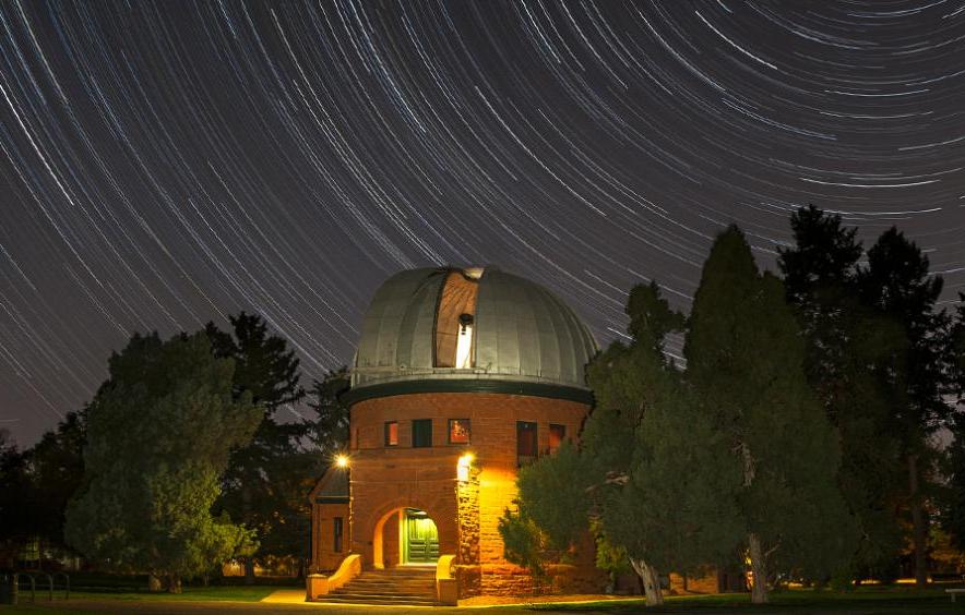 The Chamberlin Observator, an astronomical observatory in Observatory Park against the night sky. 